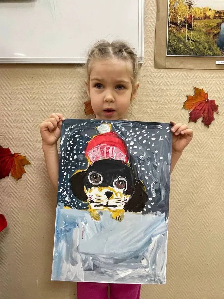 Ребёнок показывает картину, созданную на занятии