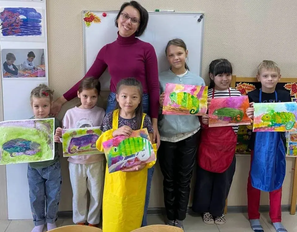 Группа детей показывает пейзажи, выполненные на занятии