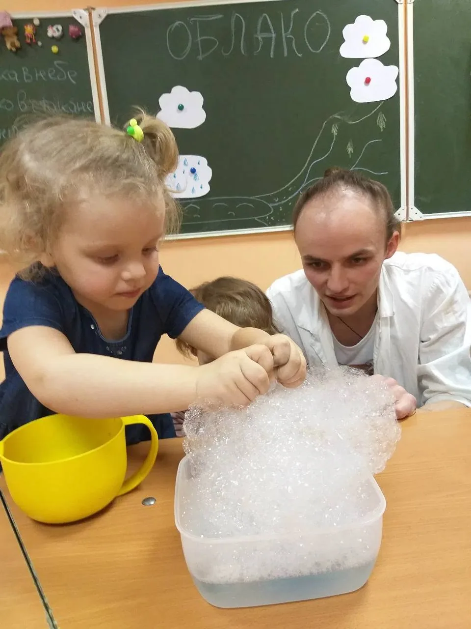 Ребёнок проводит опыт с пеной на занятии научной лаборатории