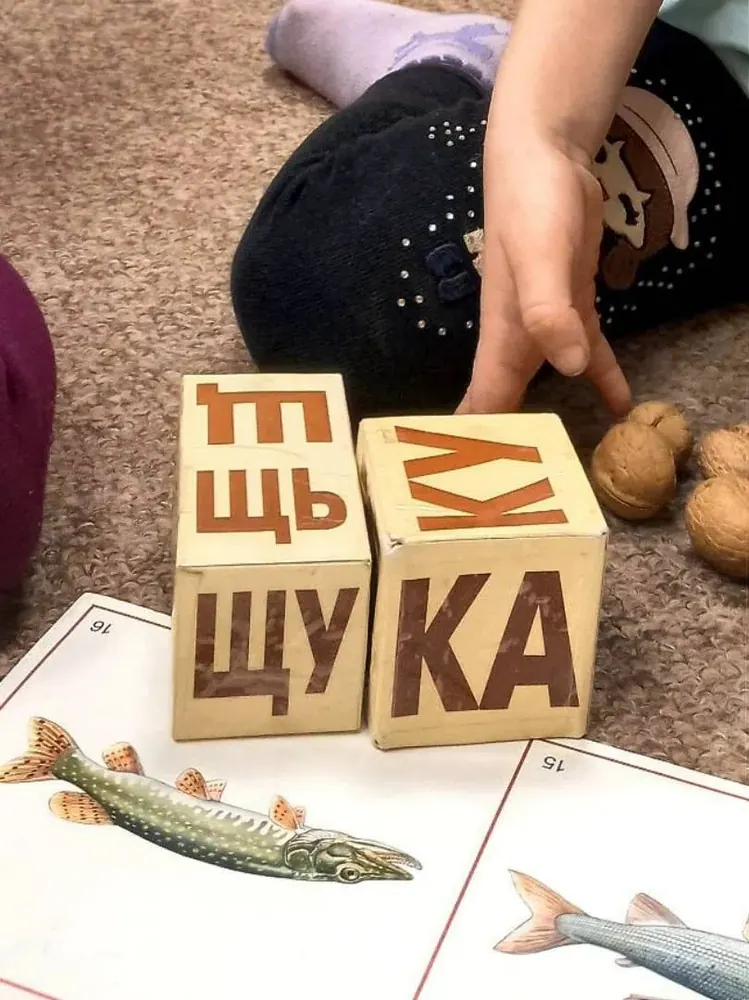 Ребёнок составляет слова из деревянных букв